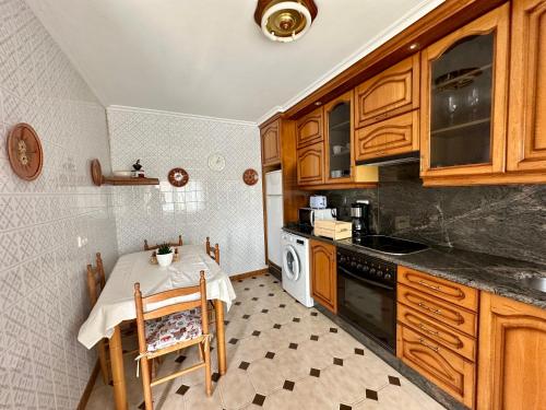 a small kitchen with a table and a stove at CasaLola - Corme Porto in A Coruña