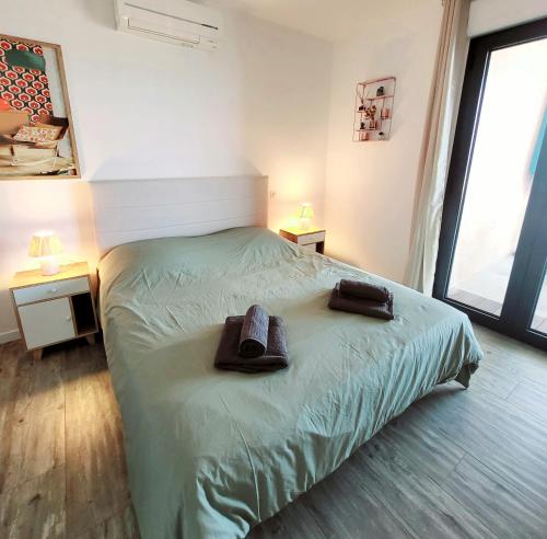 une chambre avec un lit avec deux serviettes dessus dans l'établissement Appartement de standing bord de mer, à Pietrosella