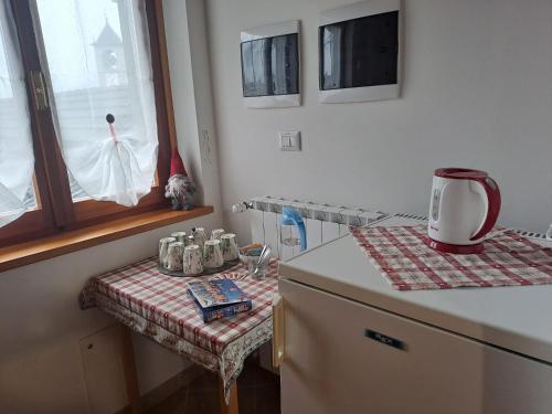 uma cozinha com um balcão, uma janela e uma mesa em B&B La vecchia posta em Antronapiana
