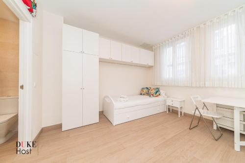 Dieses weiße Zimmer verfügt über einen Tisch und einen Schreibtisch. in der Unterkunft Marqués de Vadillo1 Apartments in Madrid
