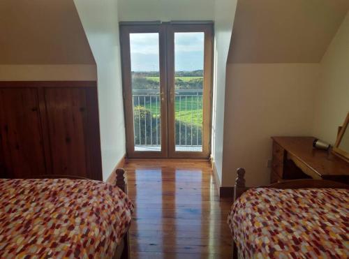 1 Schlafzimmer mit 2 Betten und einem großen Fenster in der Unterkunft Ocean Winds in Wexford