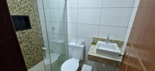 y baño con aseo y lavamanos. en casa confortável en Camaçari