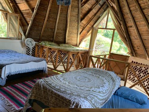 a bedroom with two beds in a room with windows at Villa Coco in Taganga