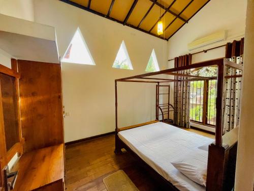 1 dormitorio con 1 cama en una habitación con ventanas en Fortress Gate Bungalow en Polonnaruwa