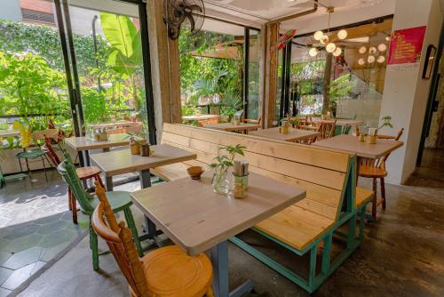 a restaurant with wooden tables and chairs and windows at Hotel El Peñon by Bithotels in Cali