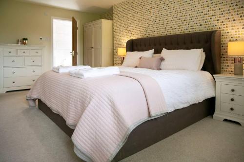 a bedroom with a large bed with two towels on it at 4 Bed House Sleeps 9 - Parking Garden Bbq Wifi in Yeadon