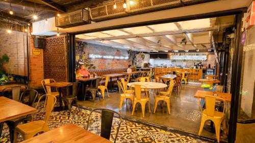 a restaurant with wooden tables and chairs in a room at Hotel El Peñon by Bithotels in Cali