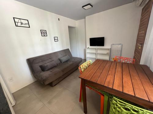 - un salon avec un canapé et une table en bois dans l'établissement Apartamentos Lagoinha, à Bombinhas