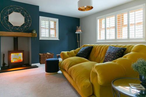 a living room with a yellow couch and a fireplace at 4 Bed House Sleeps 9 - Parking Garden Bbq Wifi in Yeadon