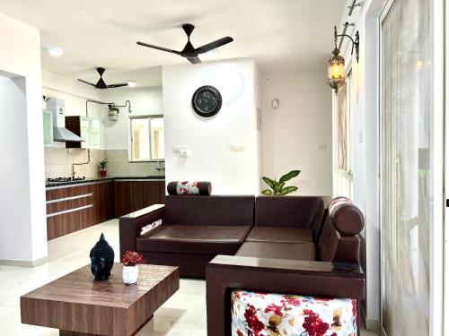 a living room with a couch and a table at BREEZE: By Aryavarta (King-sized 2 BHK apartment) in Pune