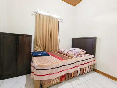 a bed sitting in a room with a curtain at Villa Cisarua Ananda in Brujul