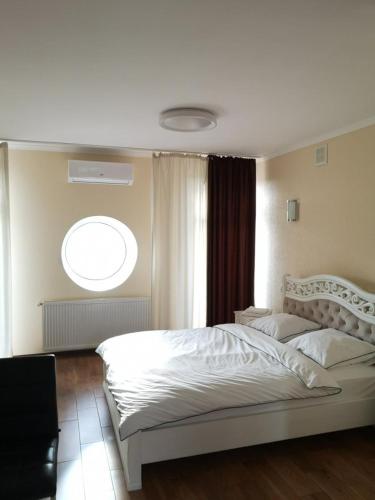 een slaapkamer met een wit bed en een raam bij Carpe Diem in Chistilov