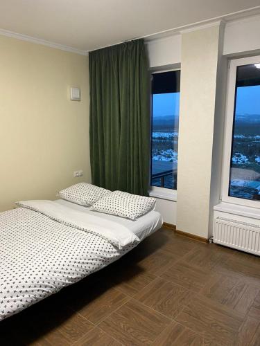 a bedroom with a bed and two large windows at Carpe Diem in Chistilov