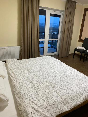 a bedroom with a large bed with a large window at Carpe Diem in Chistilov