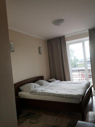 een slaapkamer met een bed en een groot raam bij Carpe Diem in Chistilov