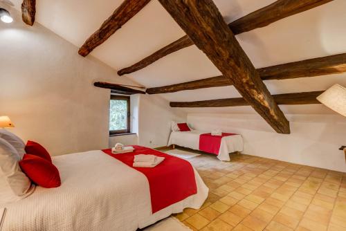 a bedroom with two beds in a room with wooden ceilings at Les Juliannes - Gîte La Pierre Etoilée Piscine Jardin in Paulinet
