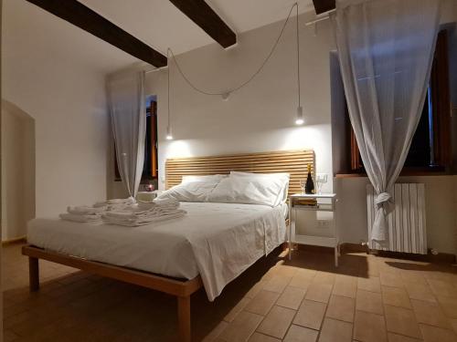 a bedroom with a white bed with a wooden headboard at La serva padrona in Iesi