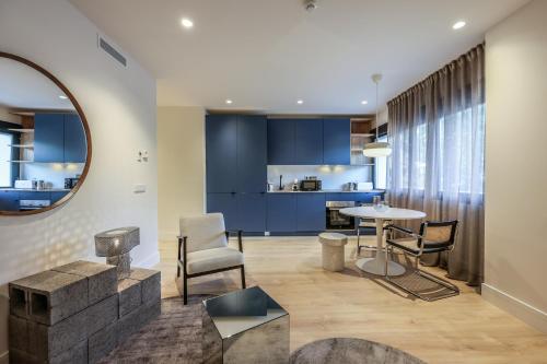 ein Wohnzimmer mit blauen Schränken sowie einem Tisch und Stühlen in der Unterkunft AmazINN Places Palacio Real in Madrid
