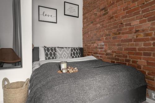 a bedroom with a bed with a brick wall at HARBOR APARTMENTS - Damrota in Katowice