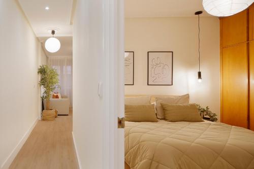 1 dormitorio con 1 cama en una habitación blanca en Emilio Tuya 60, en Gijón