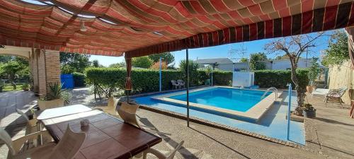 - Piscina con mesa y sombrilla en Casa Venus - con jardín y piscina, en Alcalá de Guadaira