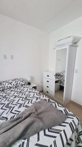 a white bedroom with a bed and a mirror at casa confortável piscina privativa in Camaçari