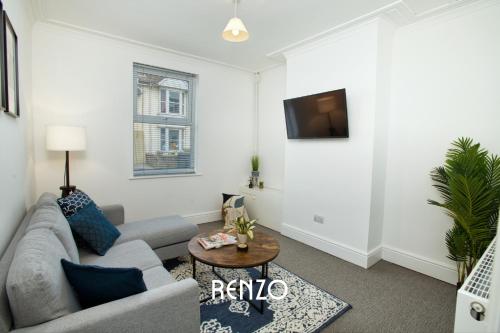 a living room with a couch and a tv at Charming 2-bed Townhouse in Lincoln by Renzo, Free Wi-Fi, Ideal for contractors in Lincolnshire