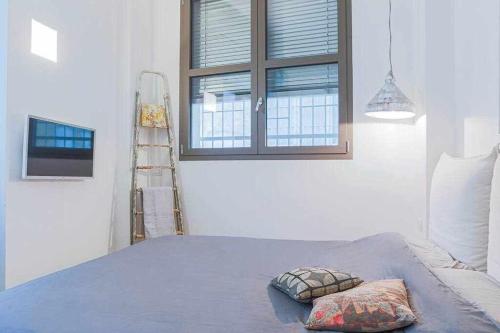 a bedroom with a bed and a ladder and a window at Cozy room in the heart of Como in Como