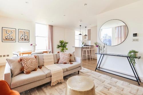 a living room with a couch and a mirror at The Wandsworth Haven - Bright 2BDR Flat in London