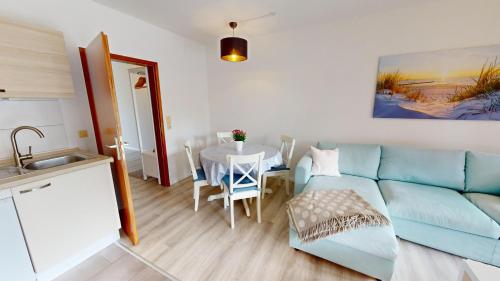 Mehrfamilienhaus "Ostseeblick" App 16 في بيلزيرهاكين: غرفة معيشة مع أريكة زرقاء وطاولة