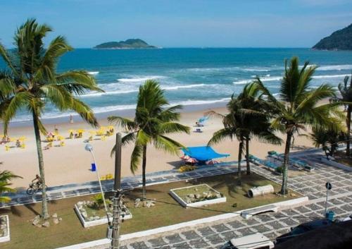 Blick auf einen Strand mit Palmen und das Meer in der Unterkunft Alma de Maré Hostel in Guarujá