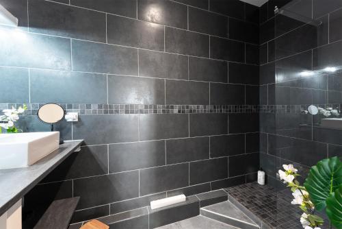 a black bathroom with a sink and a shower at Les terrasses - T3 Spacieux avec parking gratuit in Toulouse