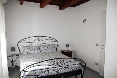 sypialnia z czarnym łóżkiem i białymi ścianami w obiekcie Giolo House w mieście Loreto