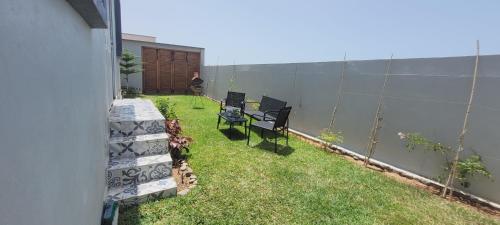 a small backyard with two chairs and a fence at Magnifique villa face à l'océan in Tiznit
