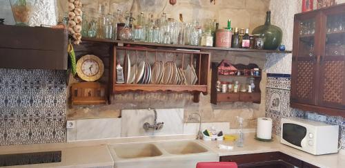 cocina con fregadero y barra con platos en La Joya de Baeza: Studio Garrido: Vivienda con Historia y Arte en el Corazón de la Ciudad Patrimonio de la Humanidad, en Baeza
