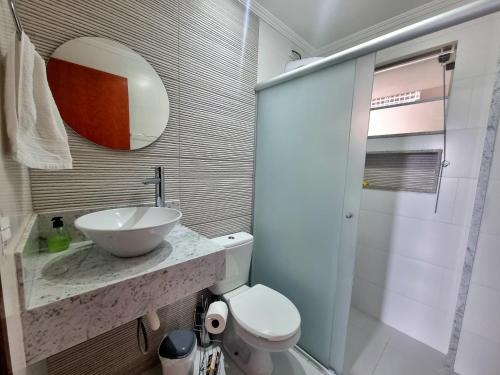 a bathroom with a sink and a toilet and a mirror at Casa Gómez in São Lourenço