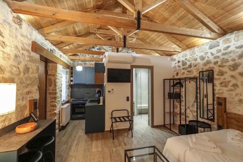 uma cozinha e uma sala de estar com tectos em madeira em Stonehouse Grace em Ioannina