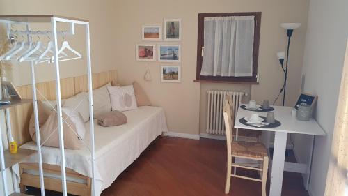 a small bedroom with a bed and a table and a desk at Glicine & more Forlì in Forlì