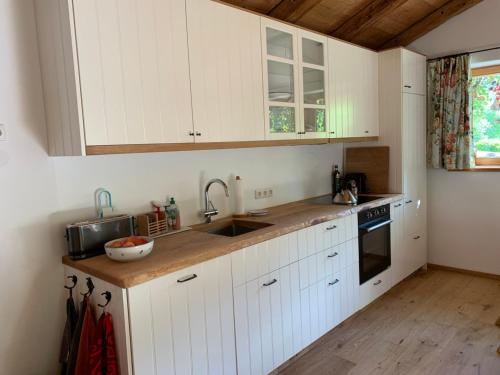 een keuken met witte kasten en een wastafel bij Zuhaus Schernfeichten in Kitzbühel