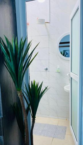 a bathroom with a plant in the corner of a room at Pilipili Kijani Luxury Homes in Mombasa