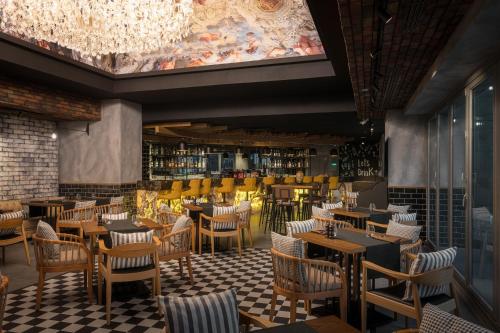 a restaurant with tables and chairs and a bar at Radisson Hotel & Residences Erbil in Erbil