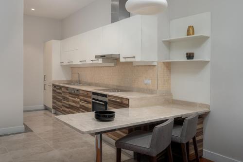 a kitchen with a counter and some chairs in it at Radisson Hotel & Residences Erbil in Erbil