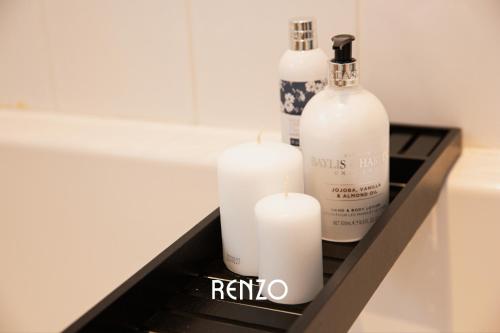 two white candles sitting on a shelf in a bathroom at Inviting 3-bed Home in Nottingham by Renzo, Victorian Features, Sleeps 6! in Nottingham