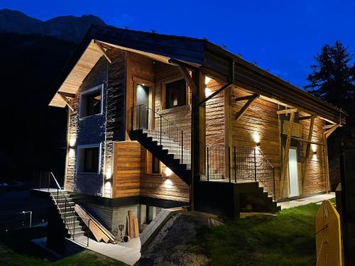 a log house with a staircase in front of it at Valgrisa Mountain Lodges 3 in Valgrisenche