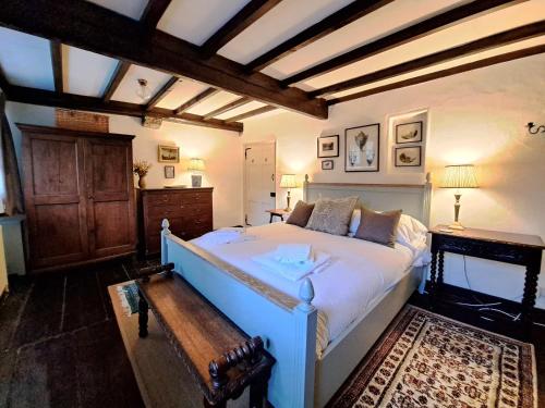 a bedroom with a large bed and a wooden ceiling at Countersett Hall in Askrigg