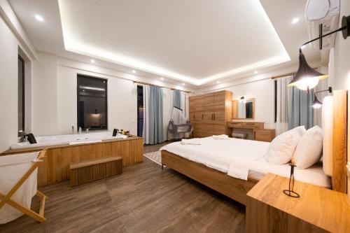 een slaapkamer met een groot bed en een bad bij Villa Sazak uno in Gelemiş