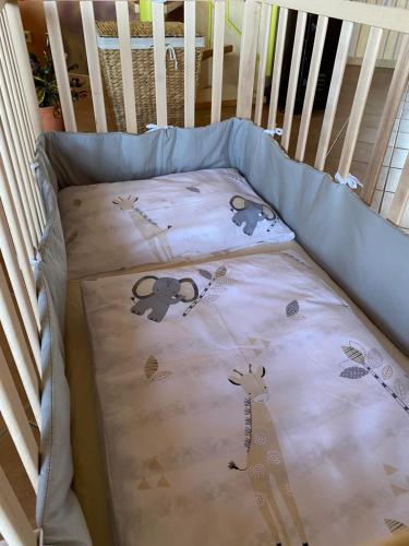 a crib bed with a blanket in a baby crib at Feriendomizil Marika in Kottenheim