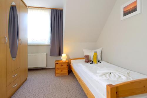 ein Schlafzimmer mit einem Bett mit einer Puppe darauf in der Unterkunft Ferienwohnung Sophia in Boltenhagen