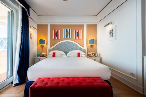 a bedroom with a large bed with a red bench at Grand Hotel San Pietro Taormina in Taormina