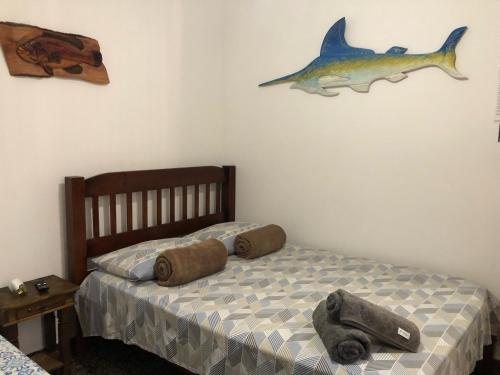 a bedroom with a bed with a fish on the wall at Suíte Trilha do Sol 2 in Arraial do Cabo